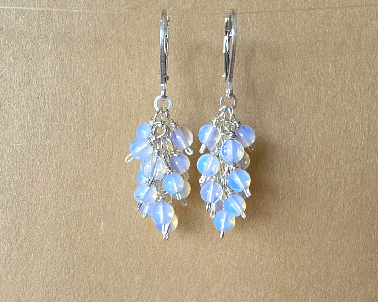 Sterling Silver Opalite Cluster earrings with blue gold stones on lever back earring hooks, with beige background 