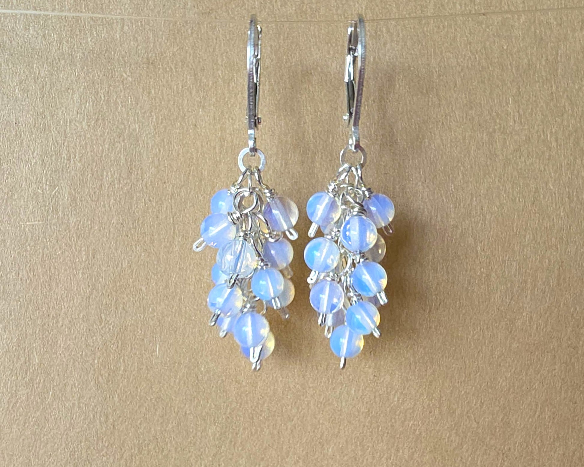 Sterling Silver Opalite Cluster earrings with blue gold stones on lever back earring hooks, with beige background 
