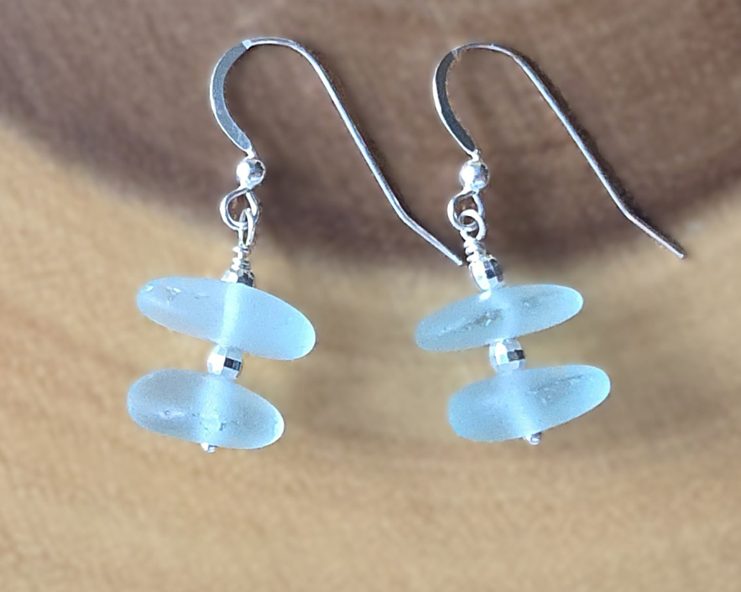 Pale Aqua blue Sea glass earrings with sparkly sterling silver beads on french style earring hooks on wood background 
