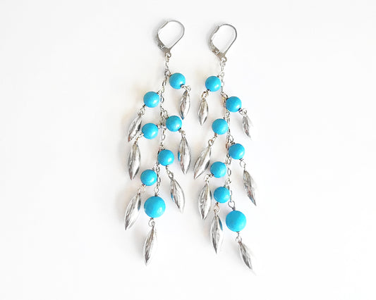 Long Turquoise Blue beaded Dangle Earrings with Pod /leaf shape silver pendants and lever back earrings hooks on white background 
