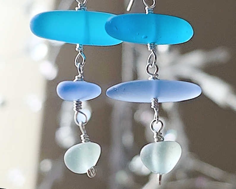 : Long Silver Sea glass earrings with three different colors of blue glass from aqua to sky blue on french style earring hooks 
