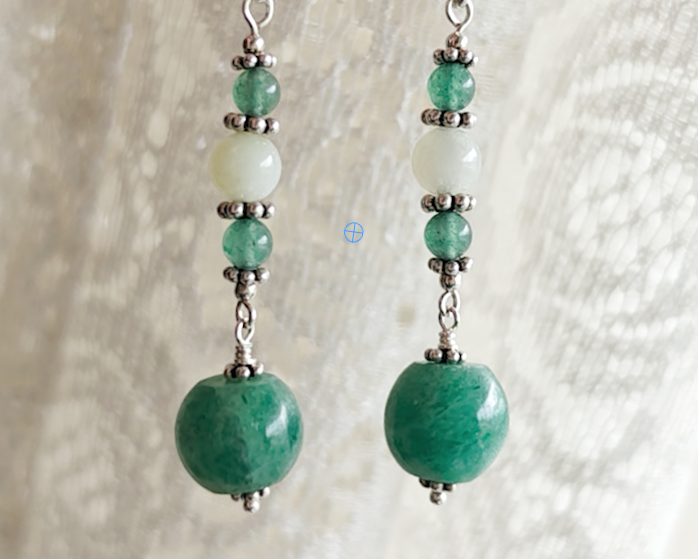 Long green gemstone earrings with deeper green aventurine and pale green jade with decorative sterling silver beads with lace background