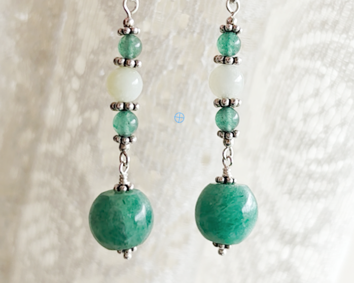 Long green gemstone earrings with deeper green aventurine and pale green jade with decorative sterling silver beads with lace background