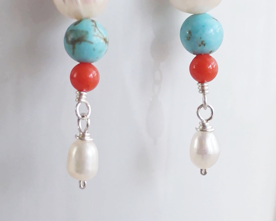 Long Turquoise Coral and Freshwater Cultured pearl dangle beaded earrings on silver french hooks on white vase