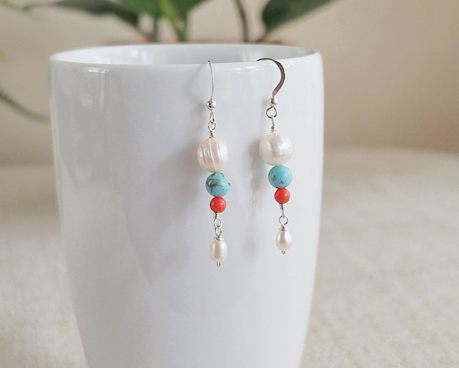 Long Turquoise Coral and Freshwater Cultured pearl dangle beaded earrings on silver french hooks on white cup 