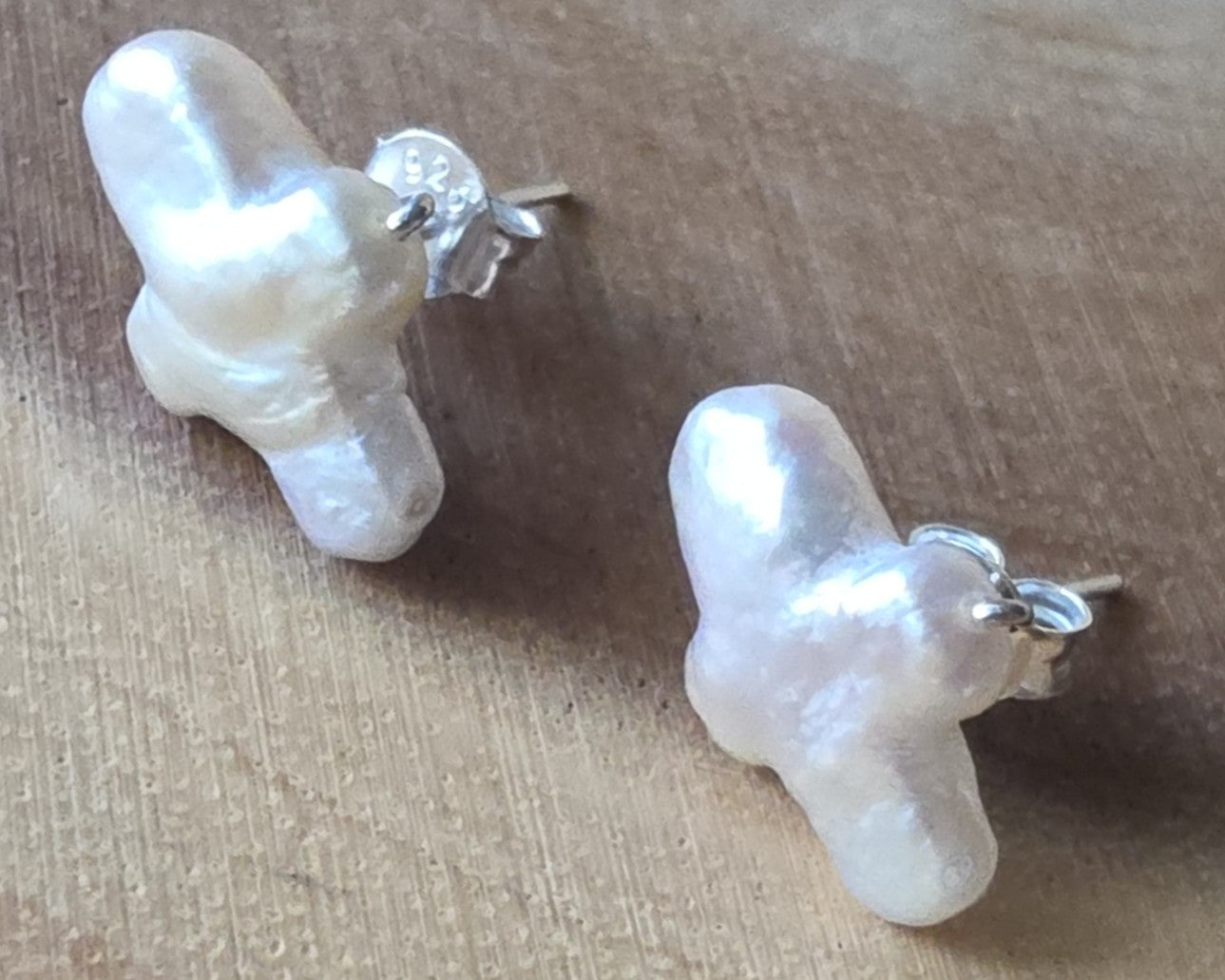 Sterling Silver Freshwater Cultured Peal Cross Stud Earrings with wood background.