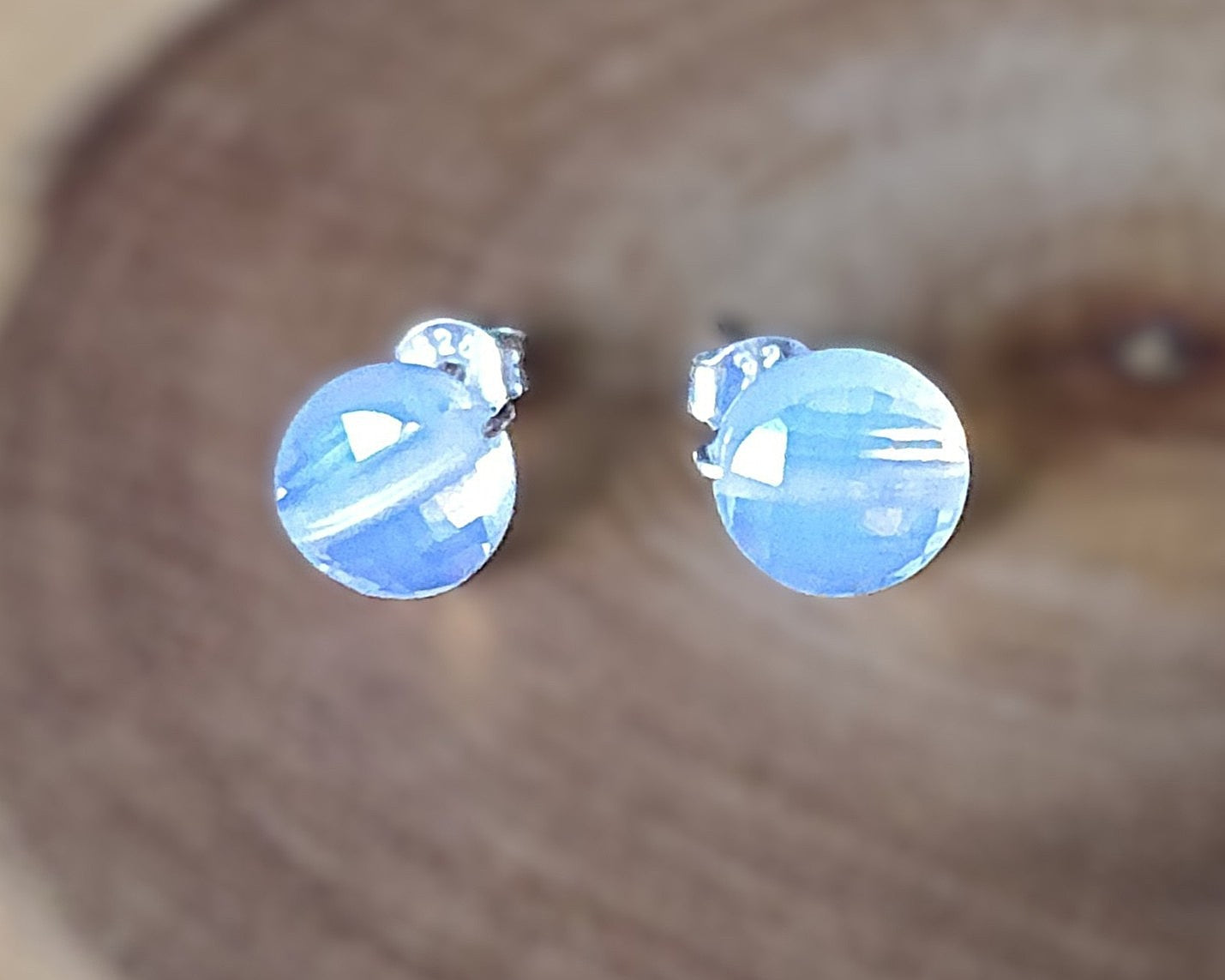 Opalite Stud earrings with milky white blue and gold hue sparkly stones on silver, displayed on wood