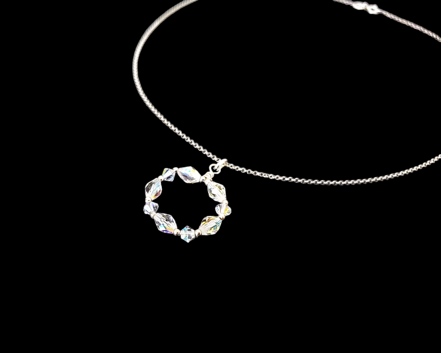 Sparkly Crystal Infinity Ring Circle Pendant on rolo chain, displayed on black background 