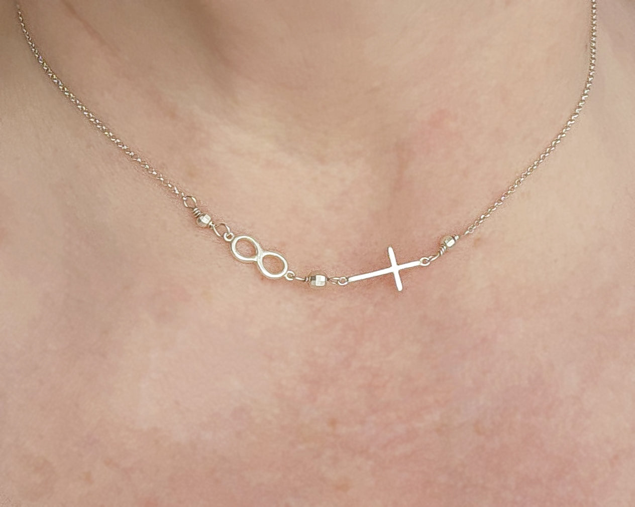 Sterling Silver Sideways Necklace with sideways Cross and Infinity symbol pendant on chain with sparkly silver beads on neck.