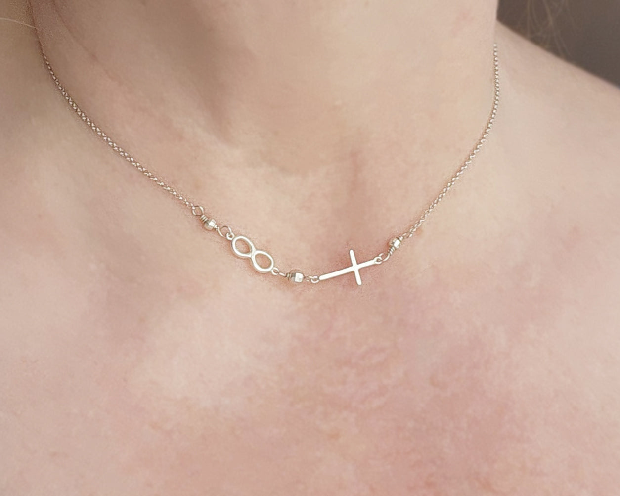 Sterling Silver Sideways Necklace with sideways Cross and Infinity symbol pendant on chain with sparkly silver beads on neck.
