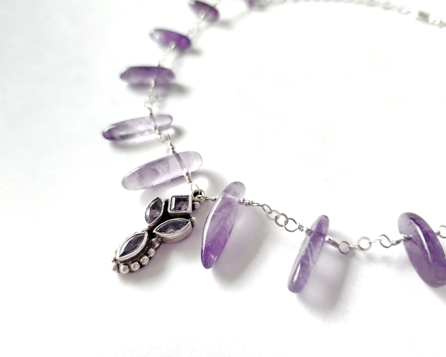 Amethyst Sterling Silver almost fan style Necklace with Decorative Silver pendant with sparkly faceted stones and wire wrapped long stones and silver chain on white background 