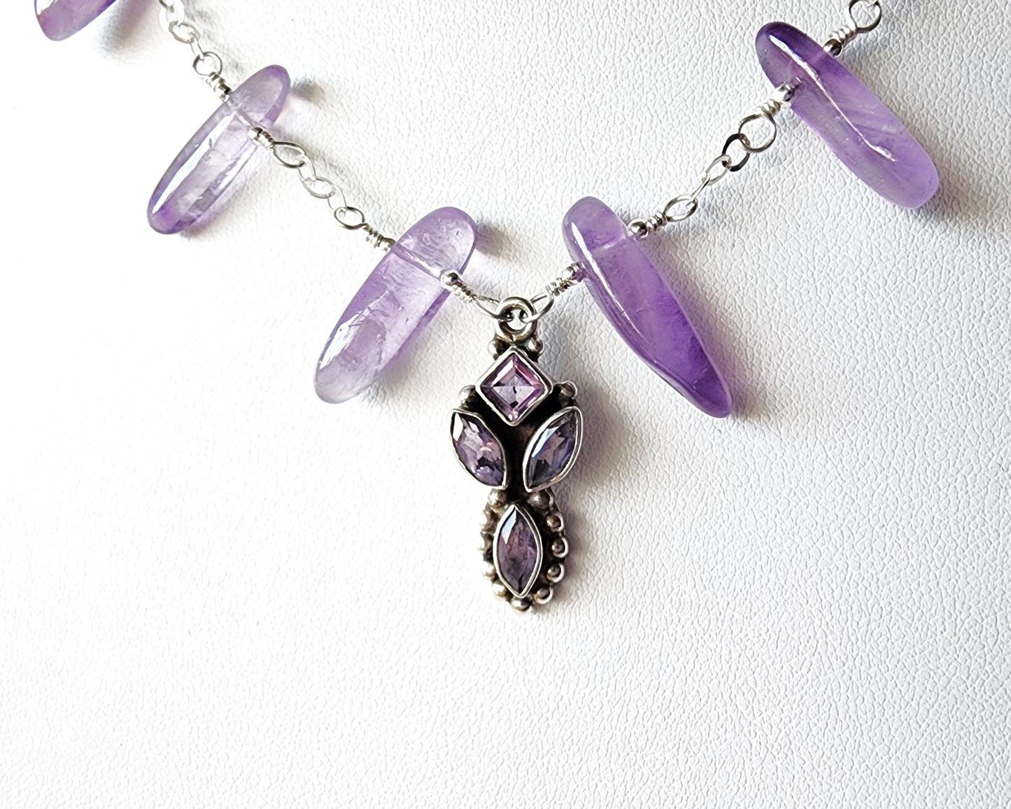 Amethyst Sterling Silver almost fan style Necklace with Decorative Silver pendant with sparkly faceted stones and wire wrapped long stones on white background 