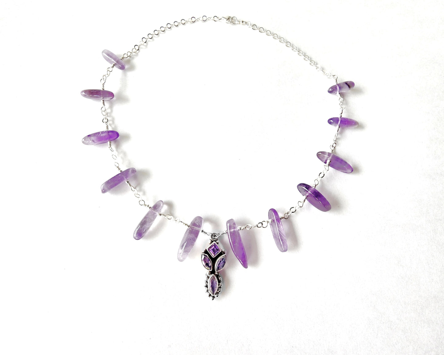 Amethyst Sterling Silver almost fan style Necklace with Decorative Silver pendant with sparkly faceted stones and wire wrapped long stones and silver chain on white background 
