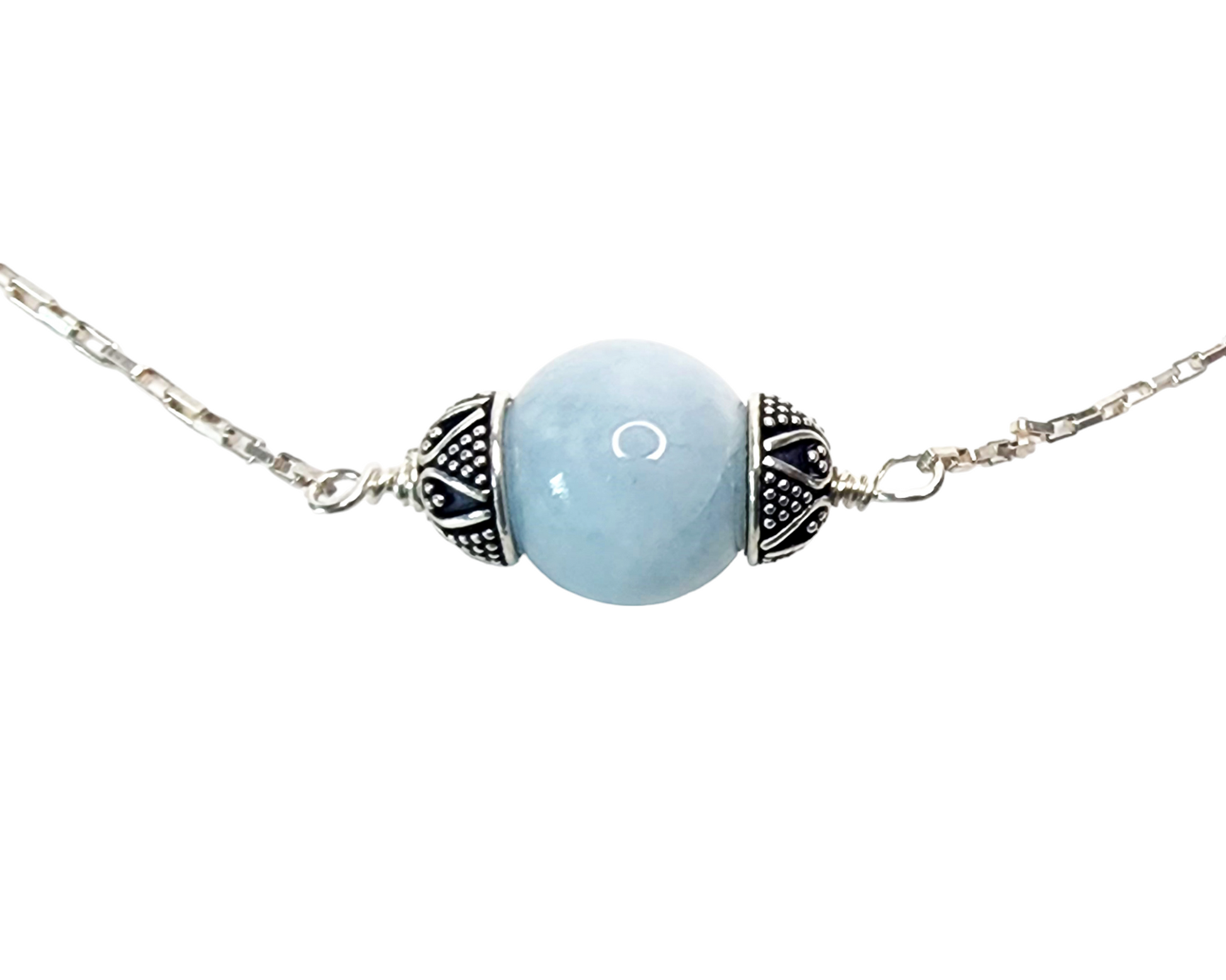 Aquamarine Necklace with one large single round polished Aquamarine stone, a floating Aquamarine accented on either side with decorative, antiqued Sterling Silver caps in centre of Sterling Silver wired to sleek shinny elongated box chain.