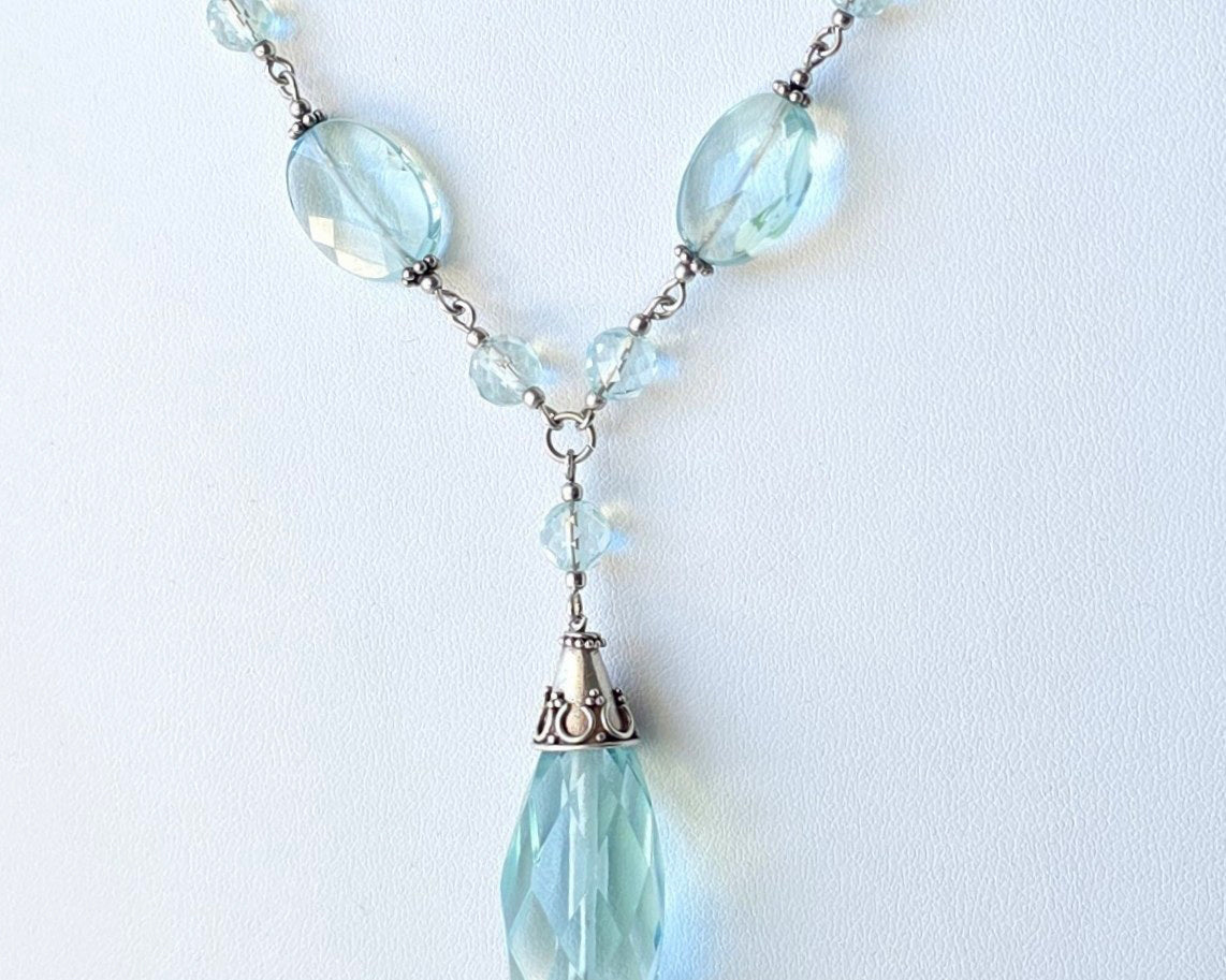 Art Deco style Aquamarine necklace made with large faceted, sparkly pale aqua blue translucent synthetic Aquamarine stones and Sterling Silver beads and chain on white background