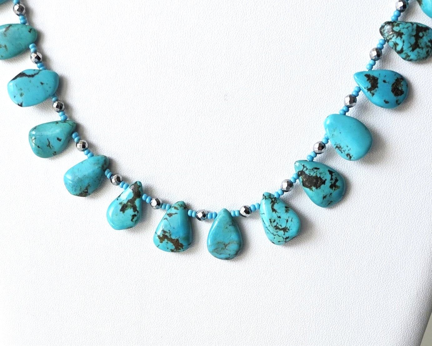 Turquoise Beaded Collar Necklace with blue Turquoise Drop Shaped Stones, sparkly silver Hematite beads and tiny glass seed beads, on white display and background 