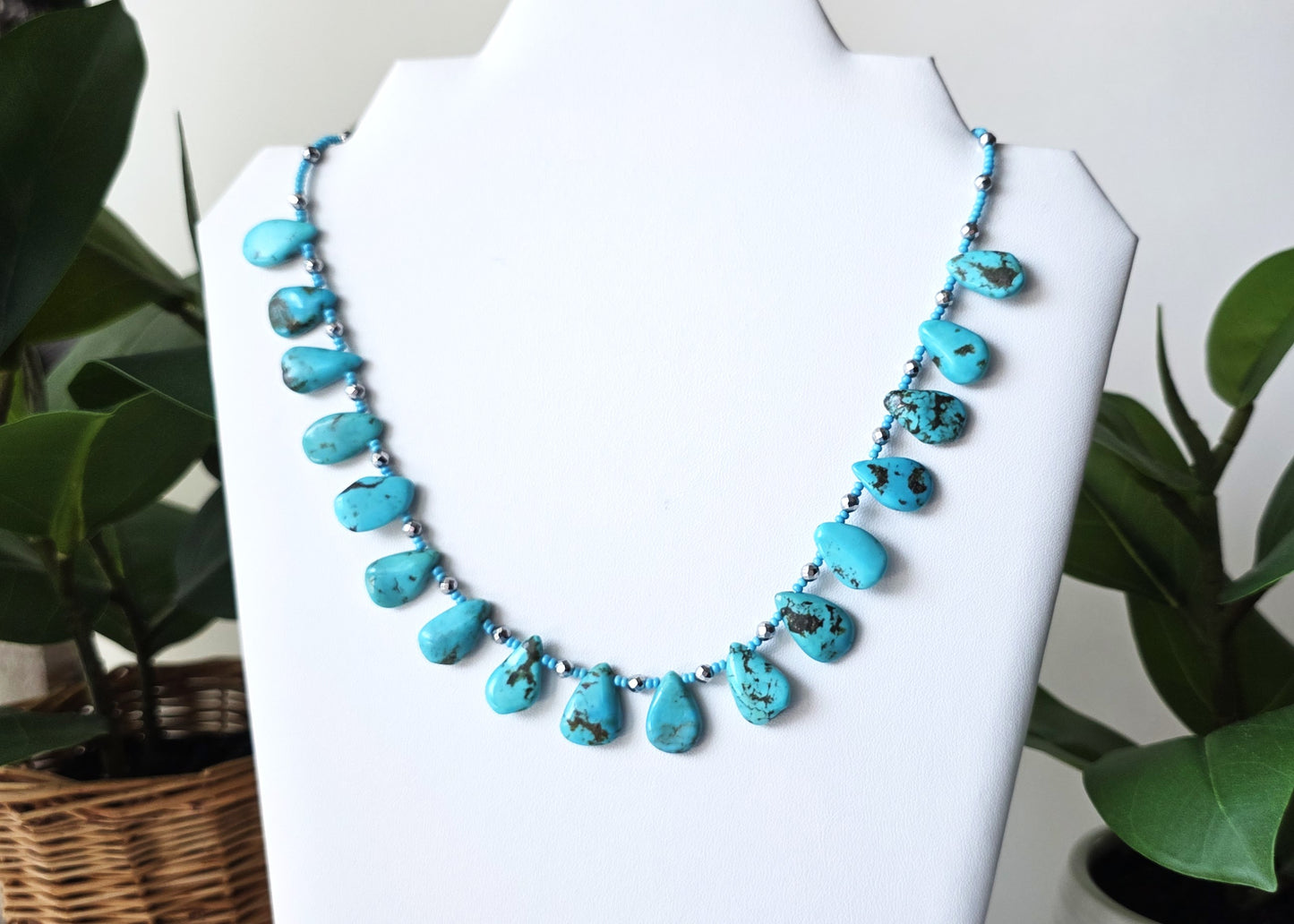 Turquoise Beaded Collar Necklace with blue Turquoise Drop Shaped Stones, sparkly silver Hematite beads and tiny glass seed beads, on white display and background 