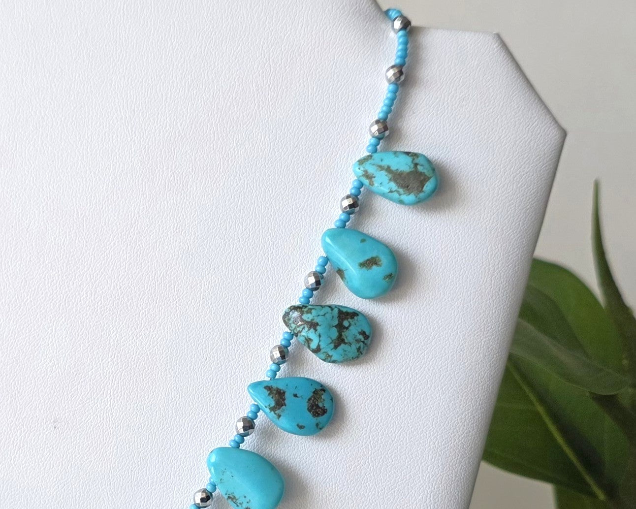 Turquoise Beaded Collar Necklace with blue Turquoise Drop Shaped Stones, sparkly silver Hematite beads and tiny glass seed beads, on white display and background 