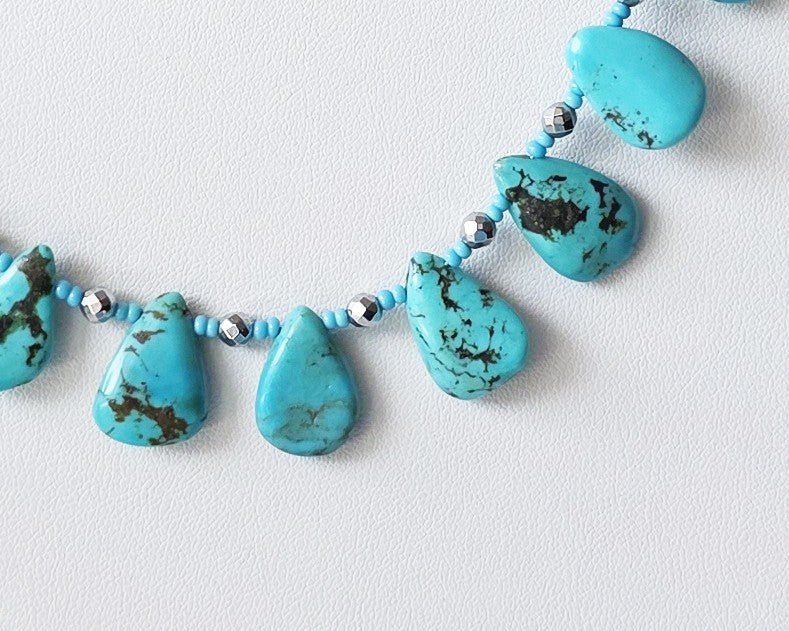 Turquoise Beaded Collar Necklace with blue Turquoise Drop Shaped Stones, sparkly silver Hematite beads and tiny glass seed beads, on white display and background 