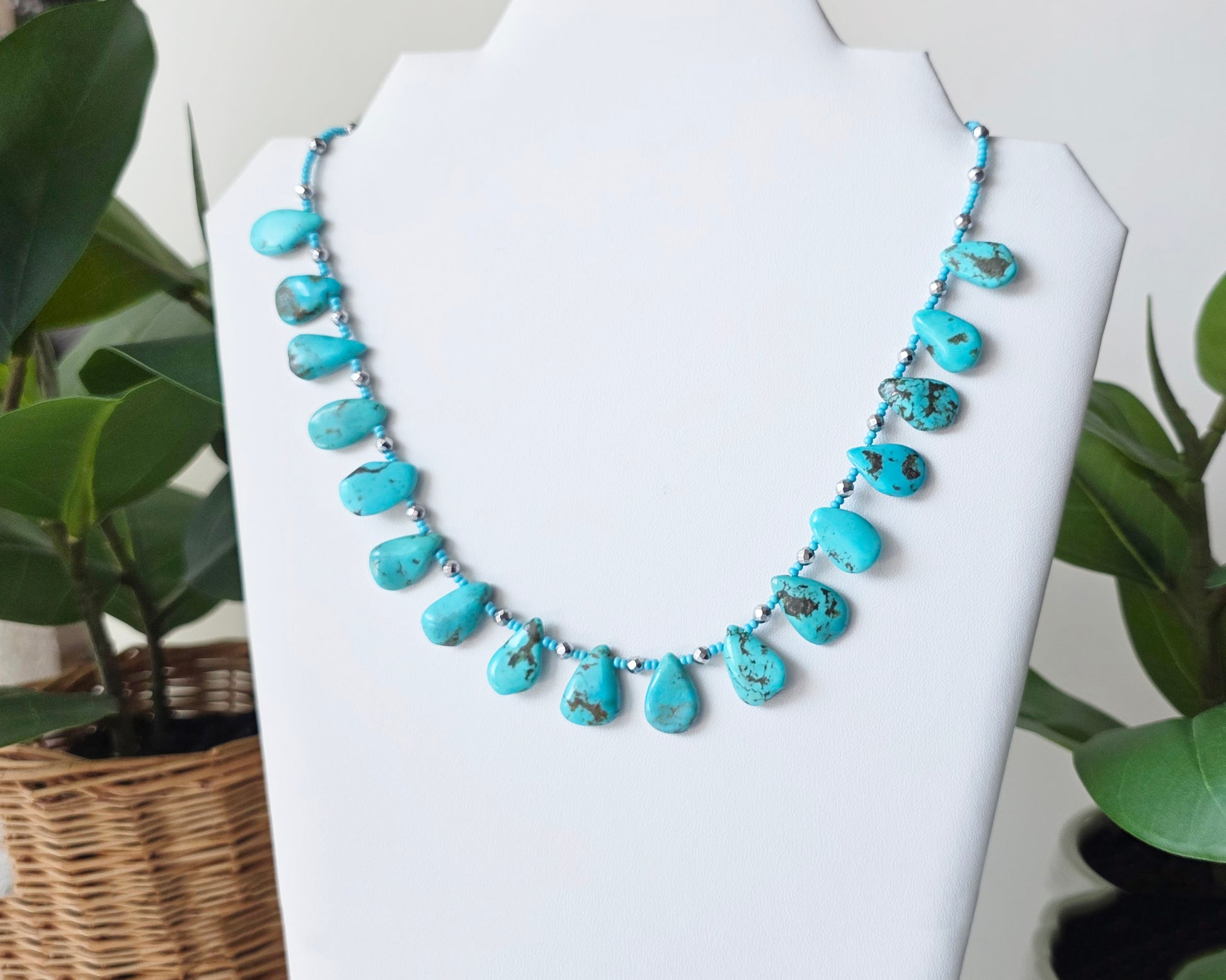 Turquoise Beaded Collar Necklace with blue Turquoise Drop Shaped Stones, sparkly silver Hematite beads and tiny glass seed beads, on white display and background 