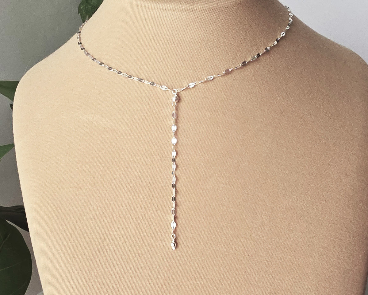 Sparkly Sterling Silver Decorative Chain Lariat necklace with brilliant flat decorative chain, sparkly faceted beads on beige background