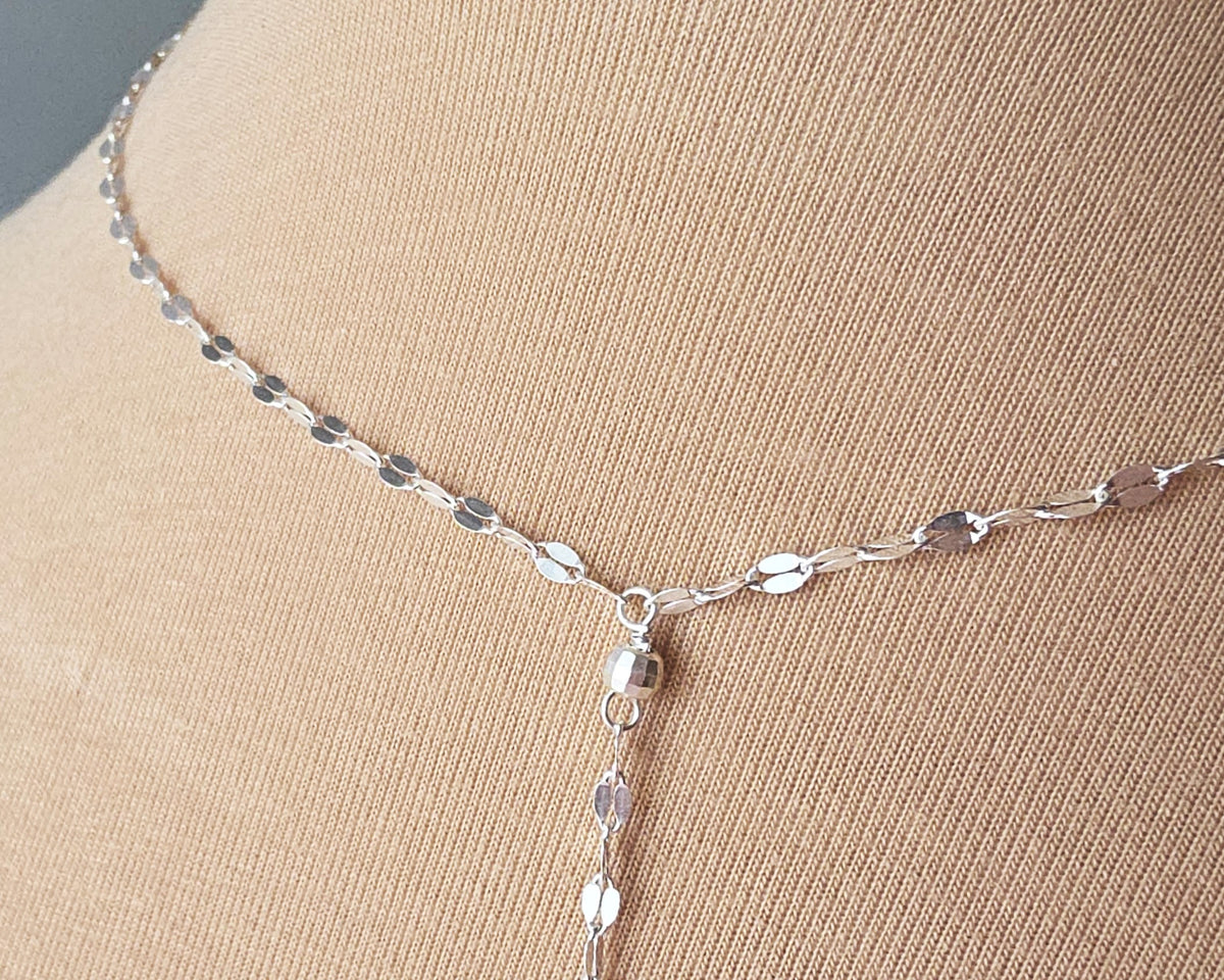 Sparkly Sterling Silver Decorative Chain Lariat necklace with brilliant flat decorative chain, sparkly faceted beads on beige background