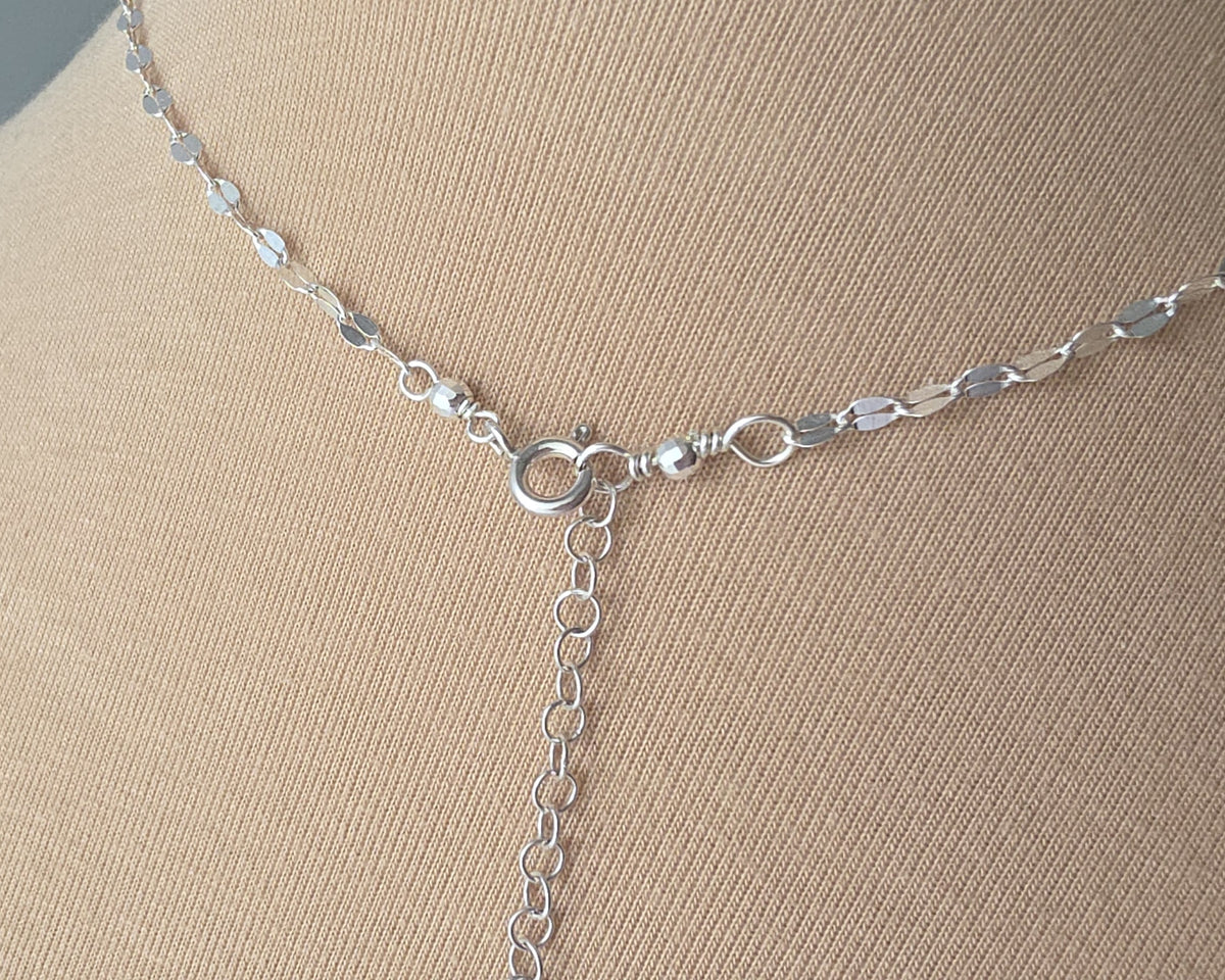 Sparkly Sterling Silver Decorative Chain Lariat necklace with brilliant flat decorative chain, sparkly faceted beads on beige background