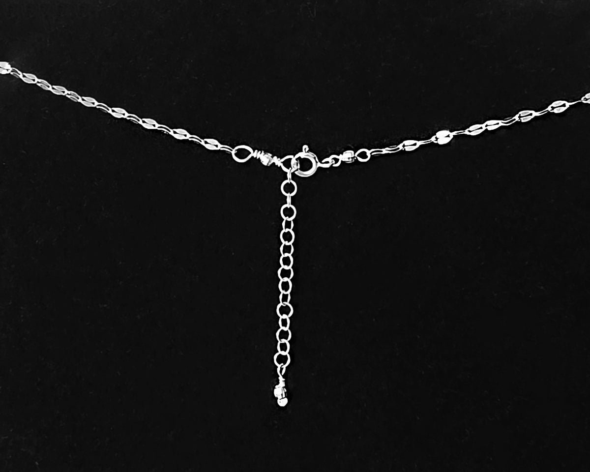 Extension chain an spring ring clasp on decorative chain, sparkly faceted beads on black background