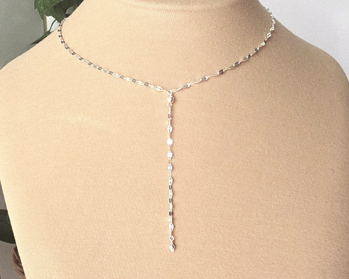 Sparkly Sterling Silver Decorative Chain Lariat necklace with brilliant flat decorative chain, sparkly faceted beads on beige background