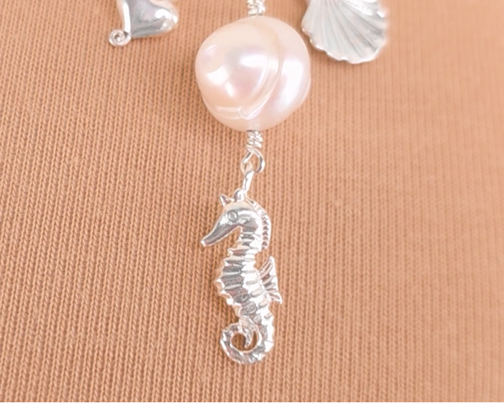  Silver Seahorse, Shell and Heart Pendants on chain with beige background