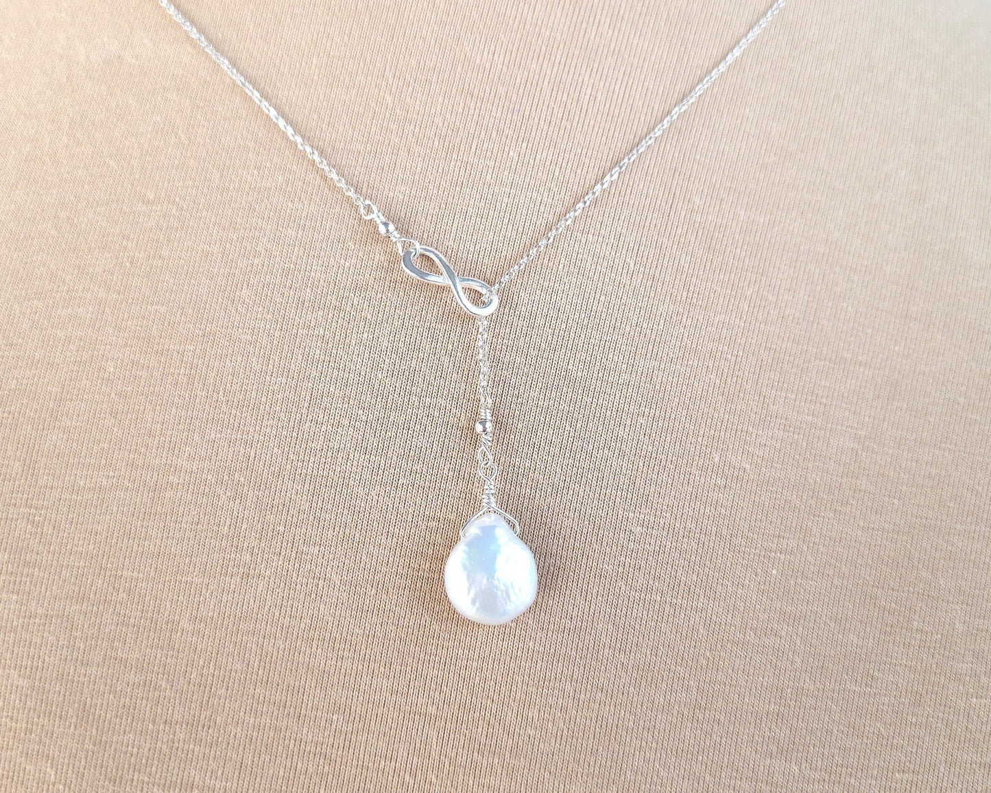 Large Pearl Drop Sterling Silver Infinity Lariat Necklace on beige display bust 