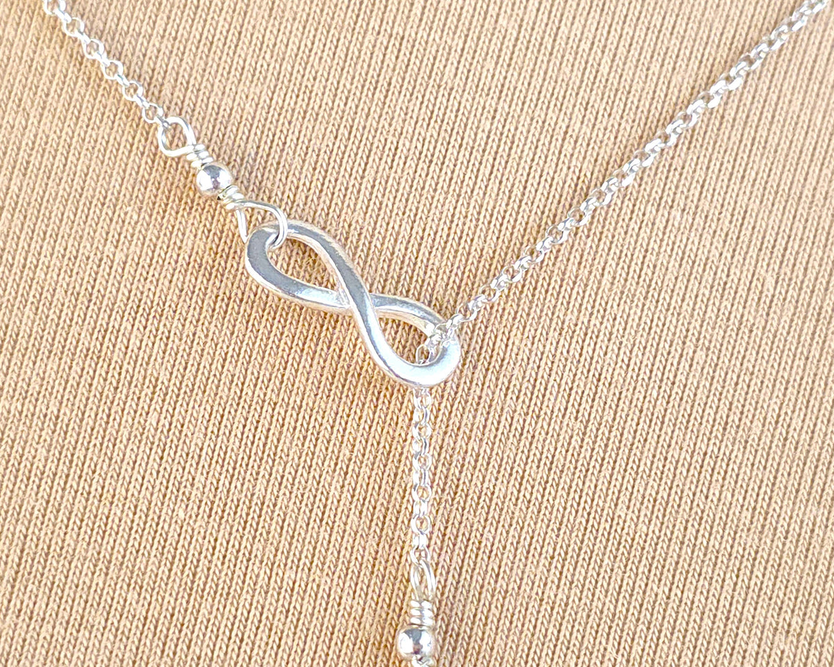  Sterling Silver Infinity Lariat Necklace on beige display 
