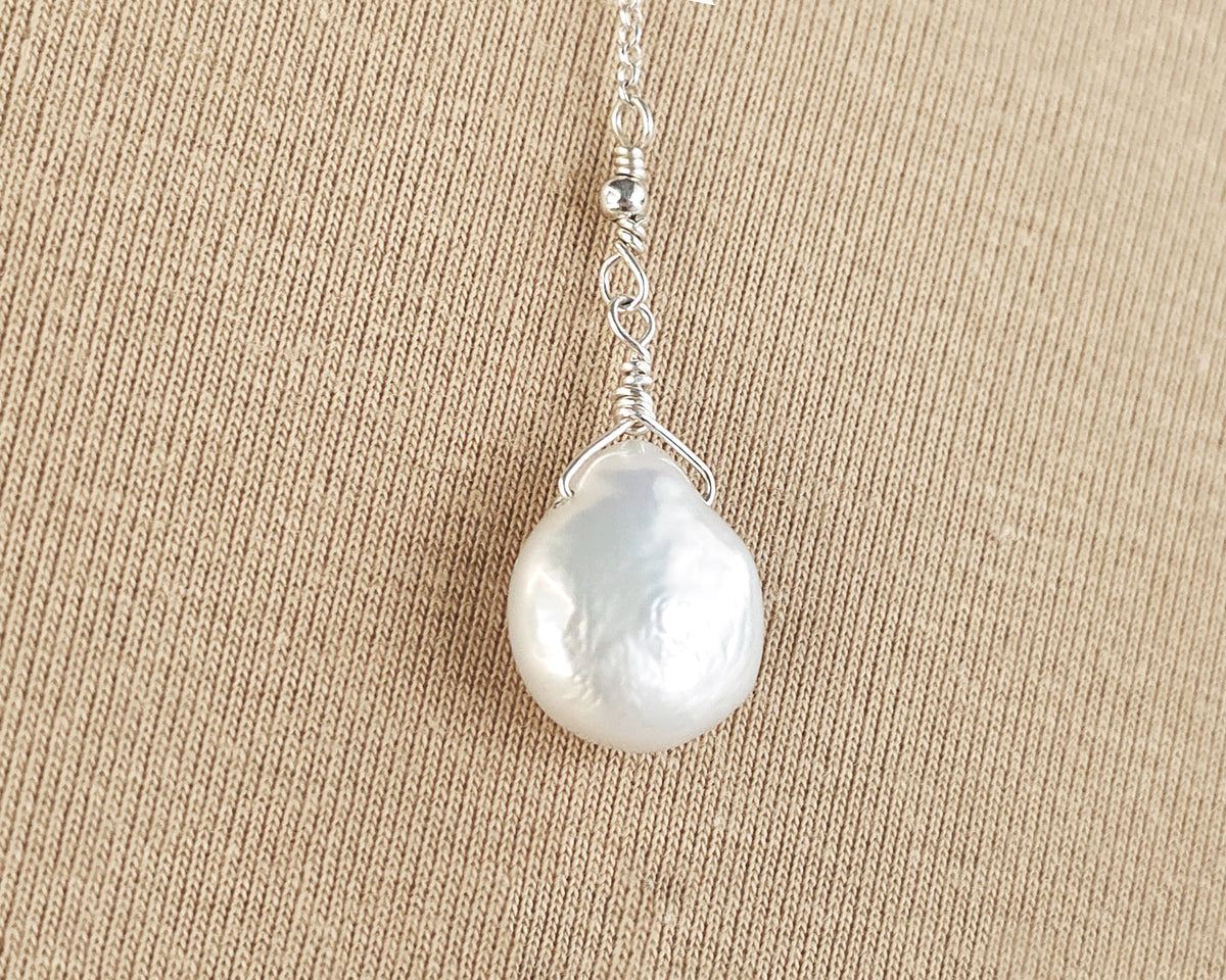 Large white Pearl Drop wire wrapped with bead and Sterling Silver wire on beige background 