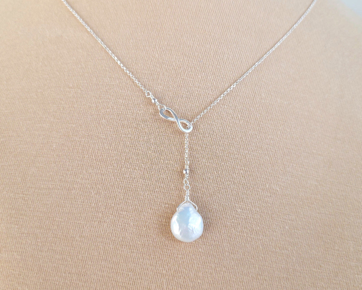 Large white Pearl Drop wire wrapped with bead and Sterling Silver wire on beige background