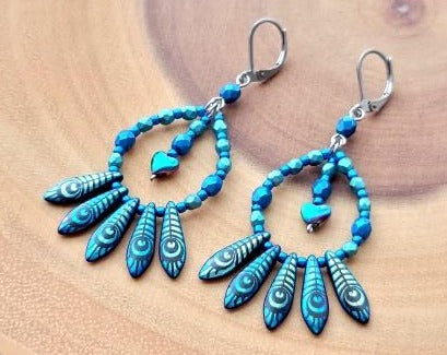 Long Dangling Hoop Fan Earrings with five peacock feather fanning the base of a drop shaped hoop made with stunning blue glass beads and a dangling titanium electroplated Hemalike heart. 