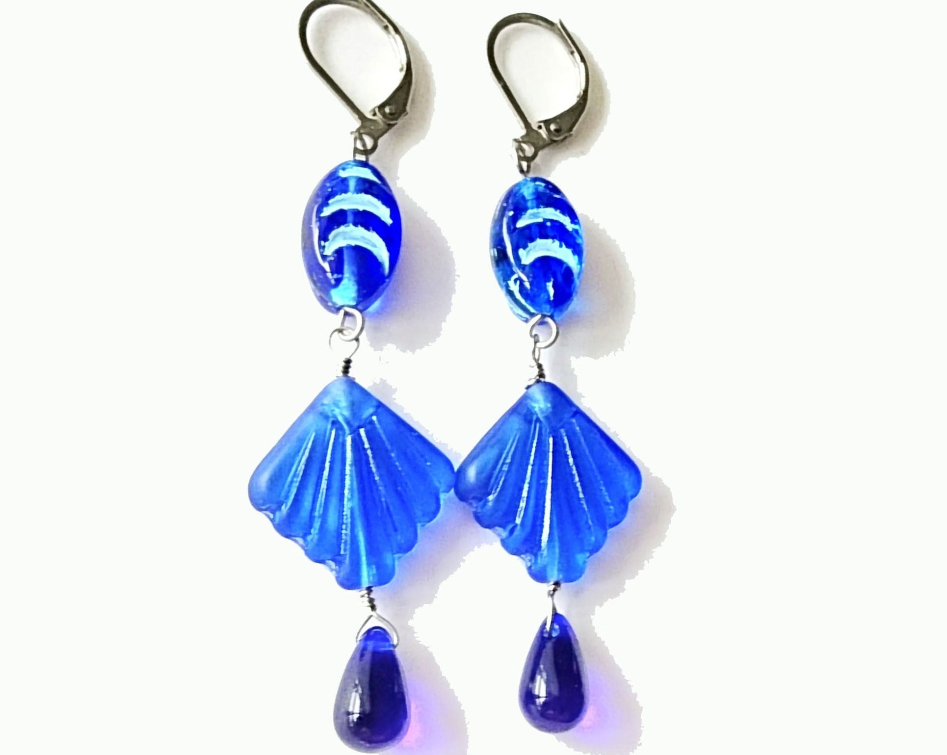 Extra Long Blue Shell Ocean Theme Earrings with sapphire blue color glass shell, wave design bead and drop shape beads on the ends. The metals is a silver color Stainless Steel.