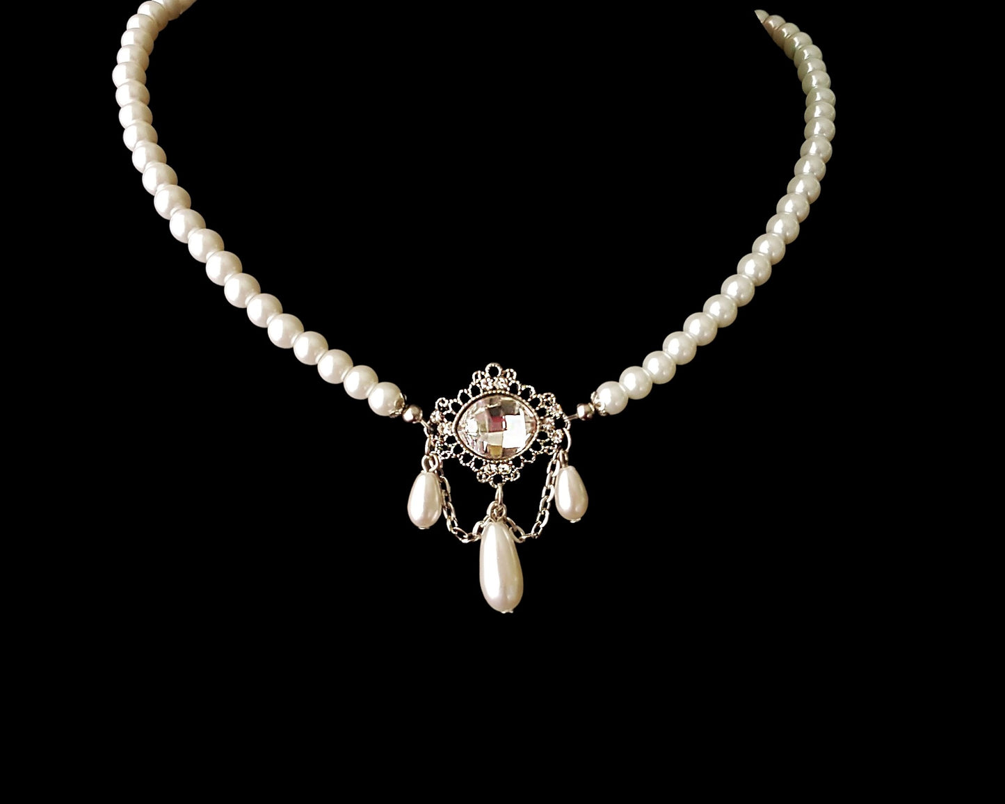 Victorian Style Pearl Crystal Necklace and Earrings Set with white pearl necklace with large clear crystal and three dangling drop pearls, displayed on black. 