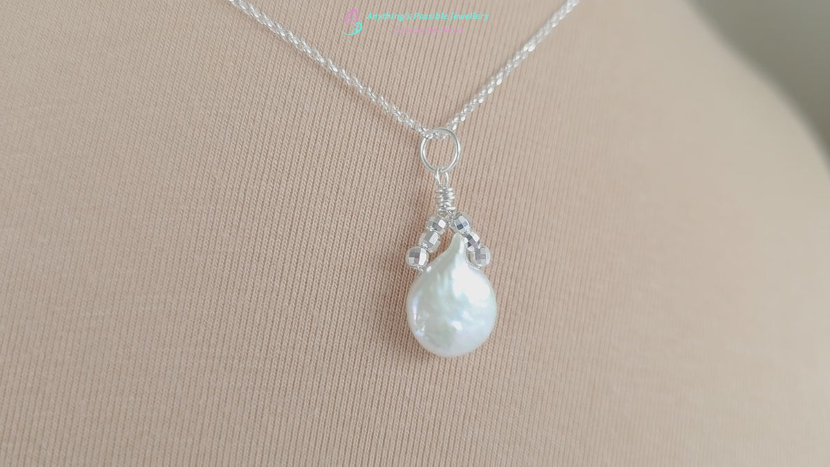 Video of  a Handmade Sterling Silver Pearl Pendant with a large rounder drop shape white freshwater Cultured Pearl with sparkly silver beads wire wrapped to a round bail on silver chain with beige background 