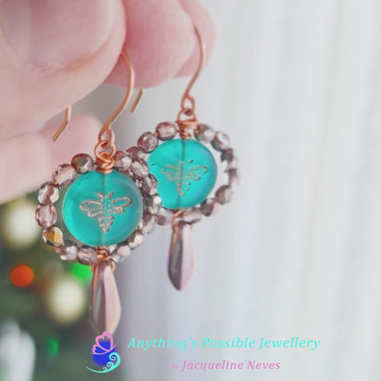 Video of a pair of handmade turquoise aqua blue glass bee earrings with gold detail, gold and copper beads and wire on french earrings hooks