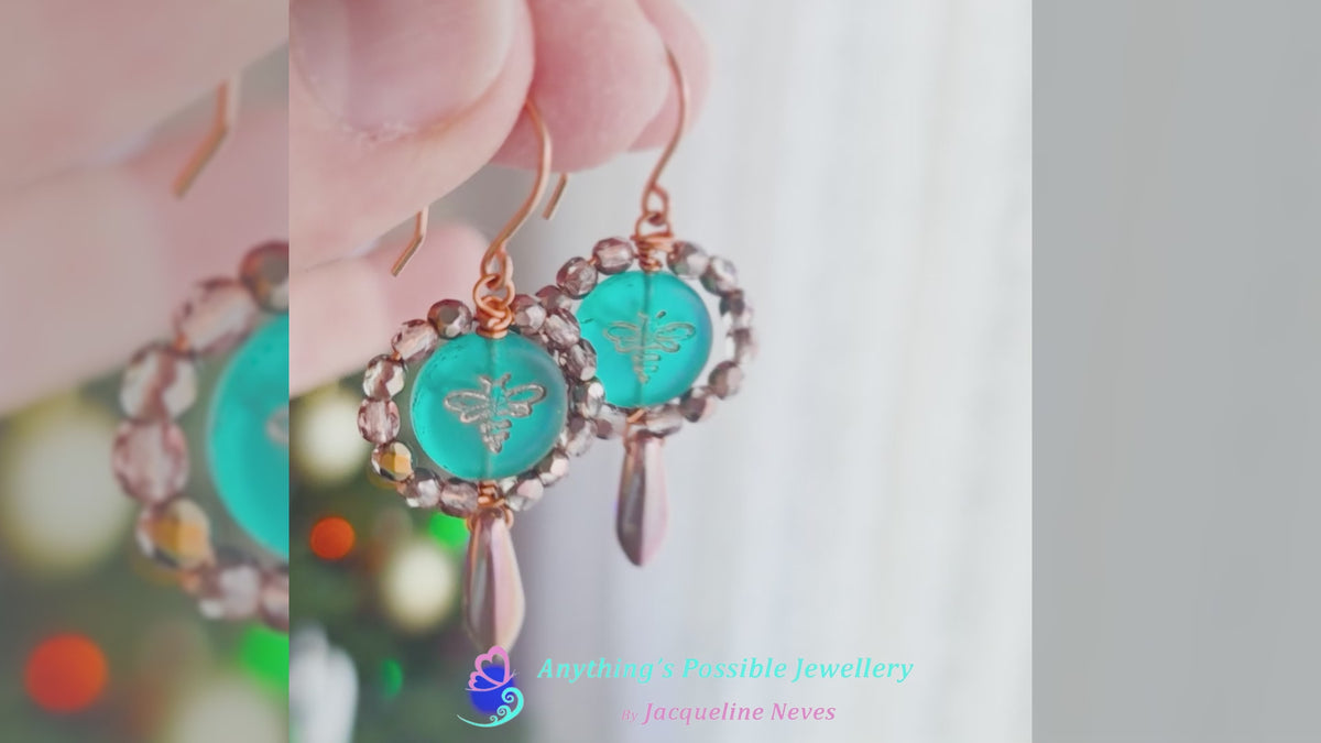 Video of a pair of handmade turquoise aqua blue glass bee earrings with gold detail, gold and copper beads and wire on french earrings hooks