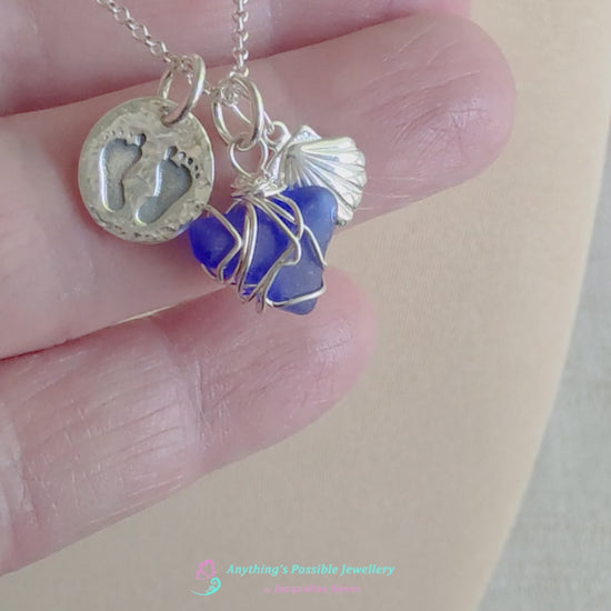 Video of Sterling Silver three charm necklace with a deep blue sea glass wire wrapped pendant with shell and footprints pendants on chain