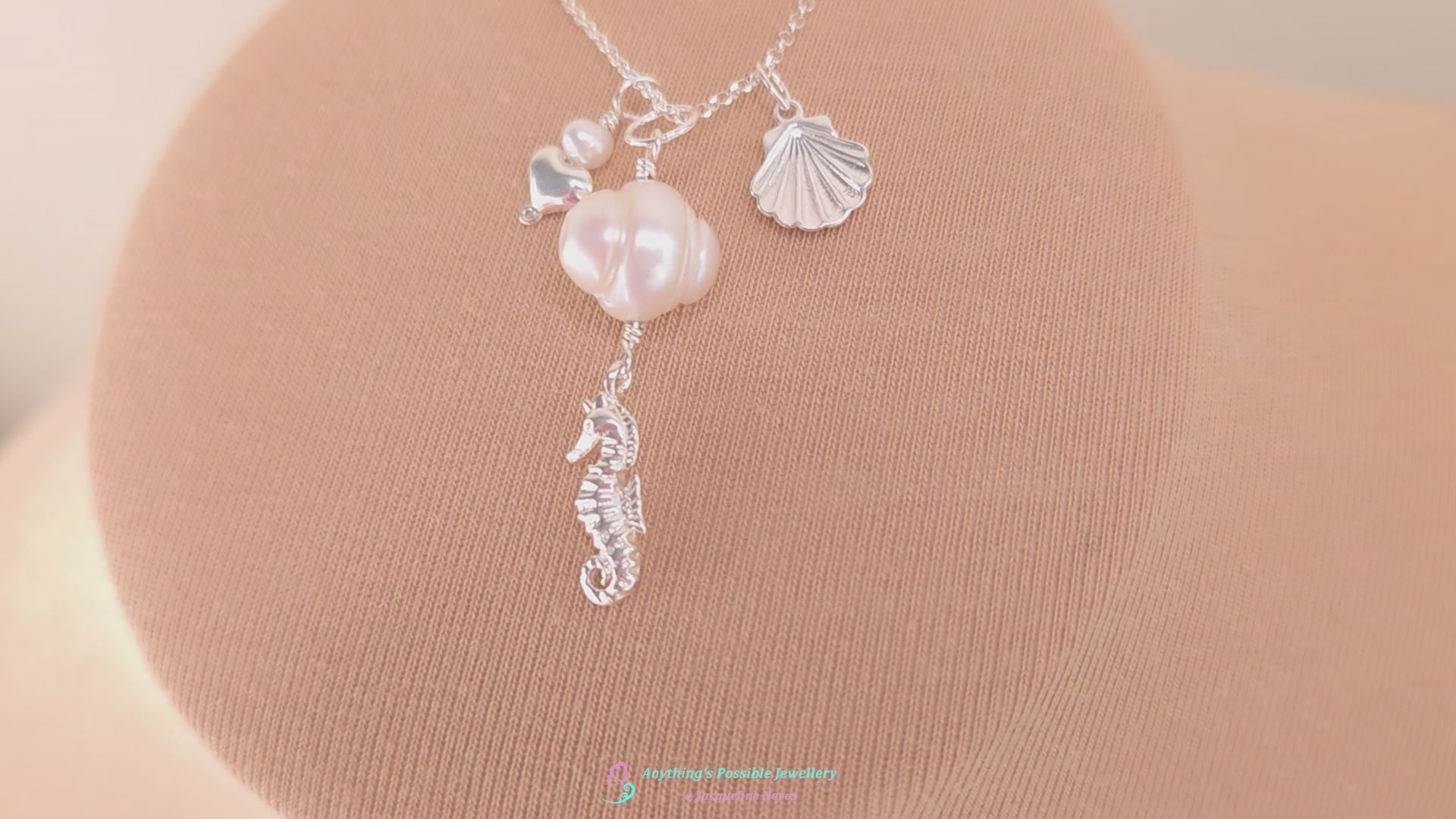 Video of Silver Necklace with white Pearls, Silver Seahorse, Shell and Heart Pendants on chain with beige background 