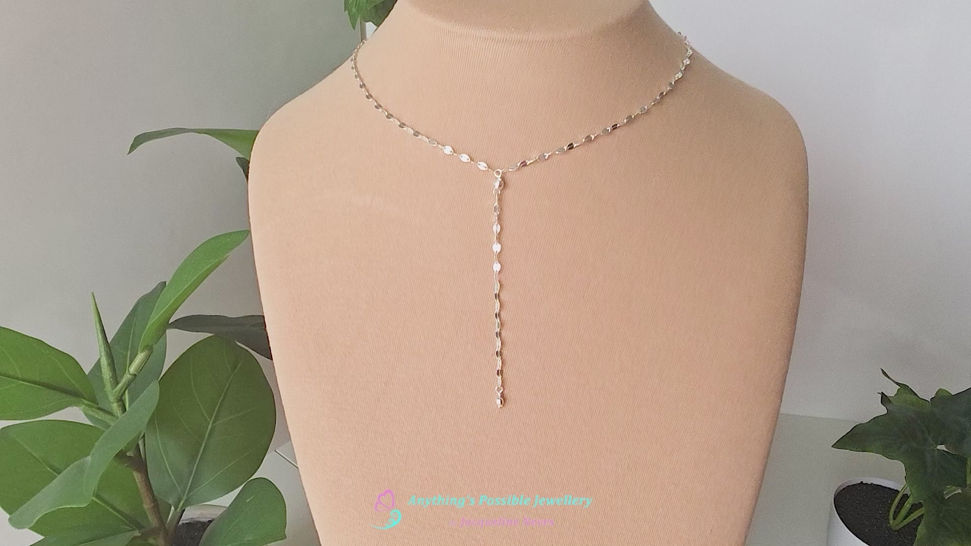 Video of a handmade Sparkly Sterling Silver Decorative Chain Lariat necklace with brilliant flat decorative chain, sparkly faceted beads on beige background