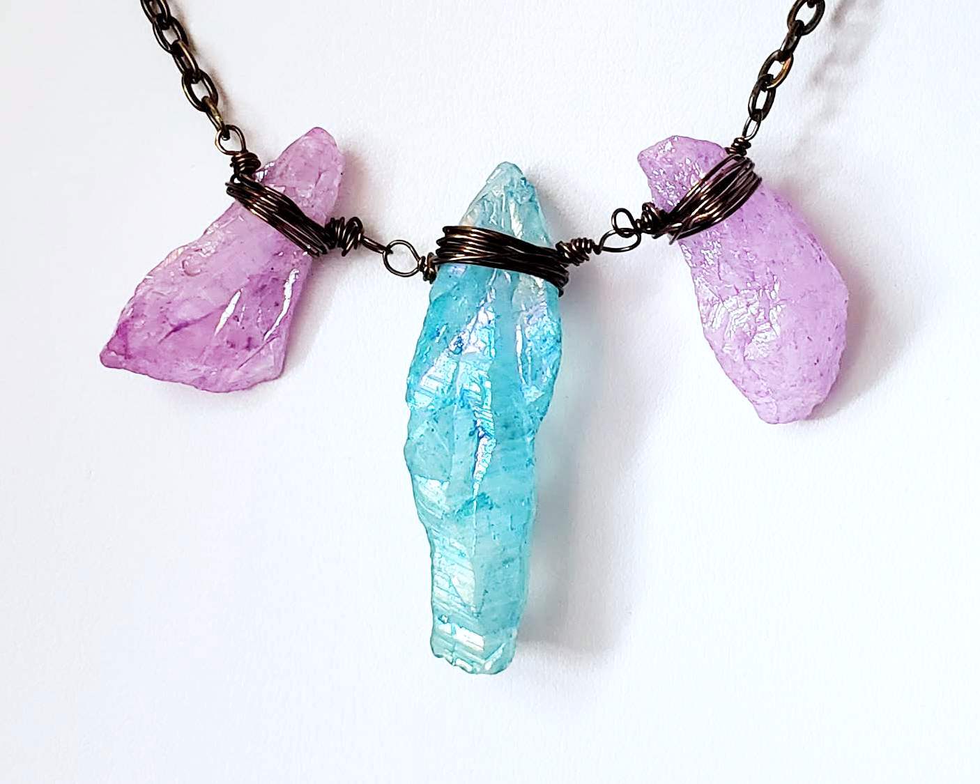 Lavender Blue Rainbow Quartz Crystal Necklace-Antiqued Brass Wire Wrapped Crystals on Chain displayed on white background 