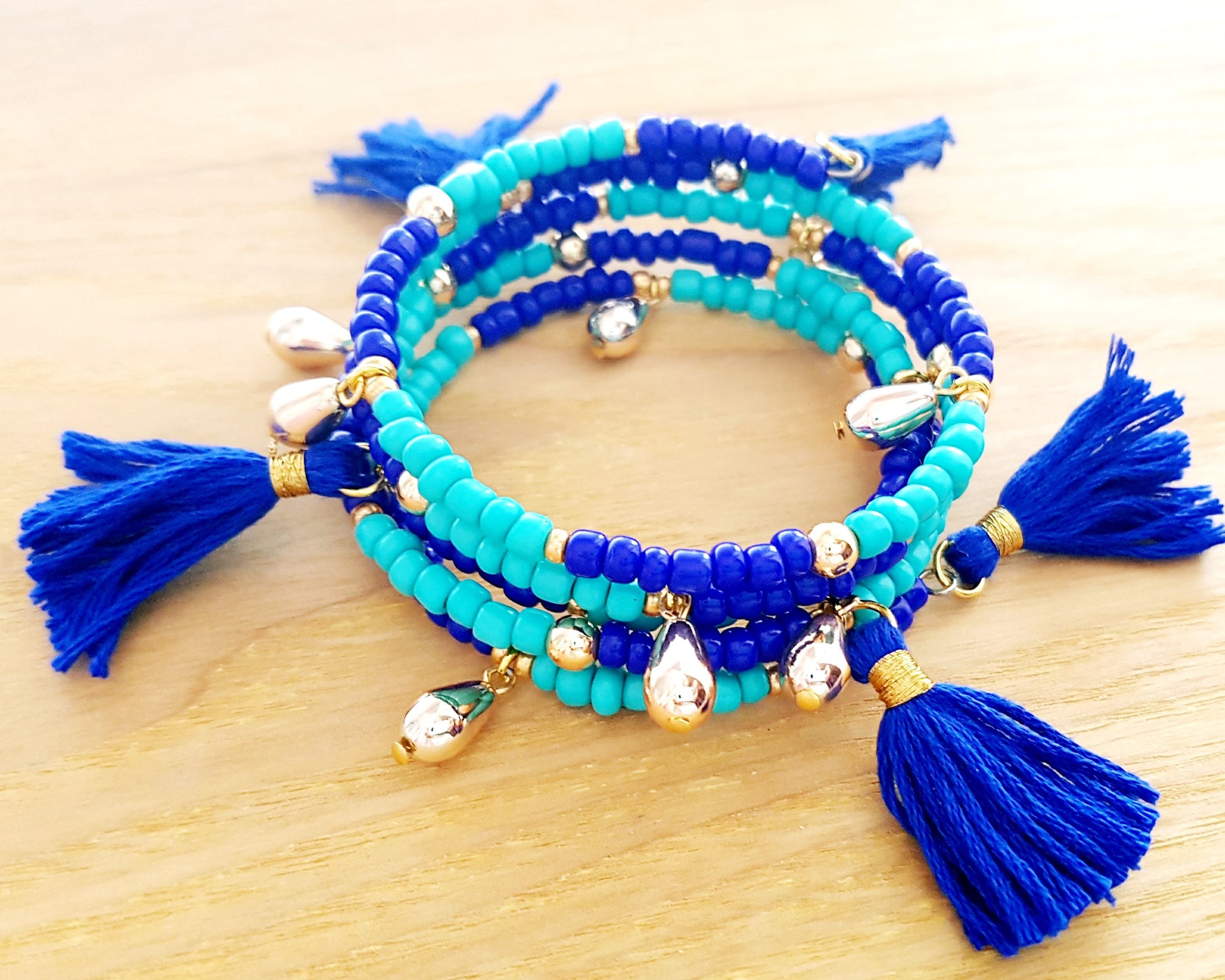 Blue Tassel Wrap Bracelet made with turquoise and cobalt blue glass beads, vintage gold tone beads and blue tassels on memory wire.