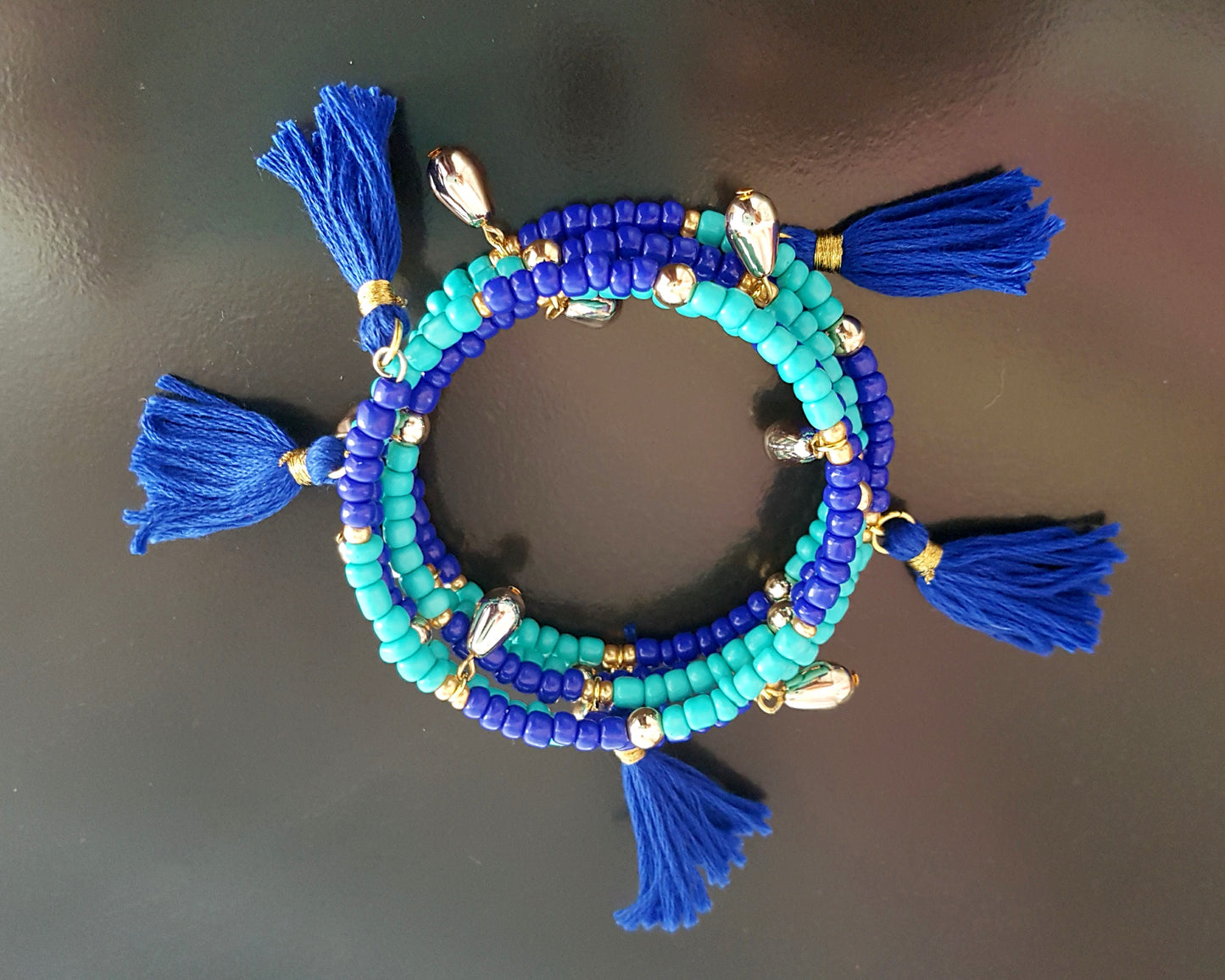 Blue Tassel Wrap Bracelet made with turquoise and cobalt blue glass beads, vintage gold tone beads and blue tassels on memory wire.