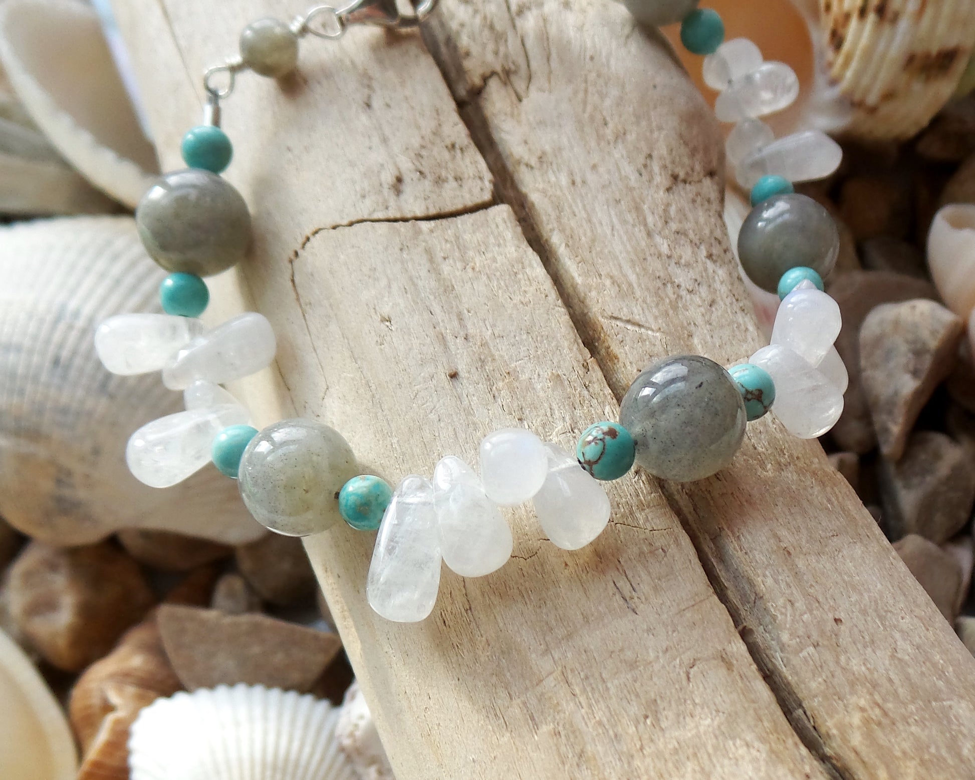 Moonstone Labradorite Turquoise Beaded Gemstone Bracelet with Sterling Silver lobster claw clasp, on Beach Wood background 