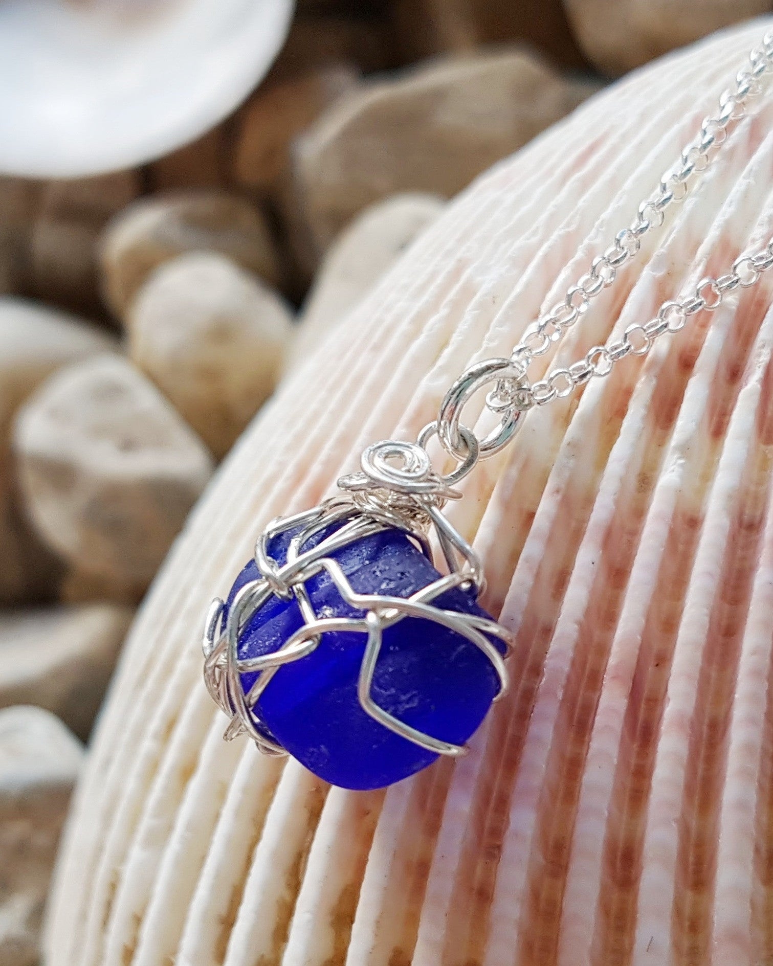 Blue Passion Sea Glass, Lake Glass-Bach GlassSapphire Blue Passion Beach Glass Pendant Necklace, Sterling Silver wire wrapped blue beach glass pendant on rolo style chain. Displayed on shell