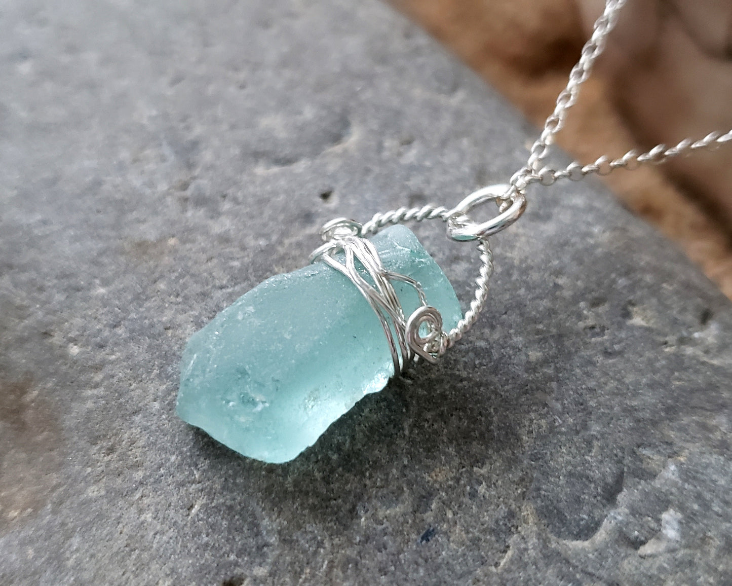 Aqua Blue Beach Glass Serenity Pendant Necklace on grey Stone background 