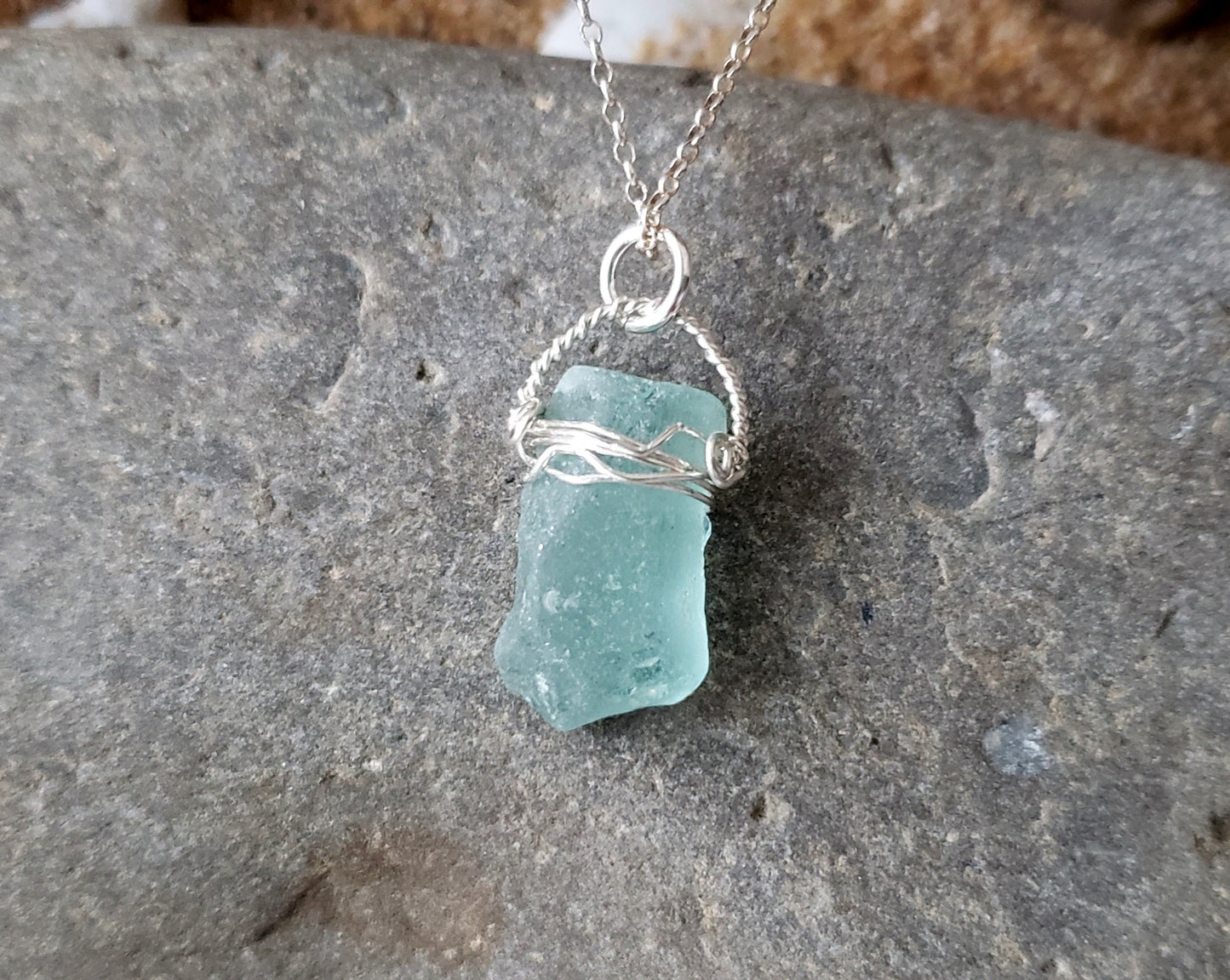 Aqua Blue Beach Glass Serenity Pendant Necklace, full view of pendant on a grey stone background